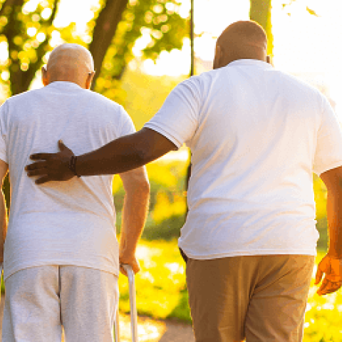 caregiver helping man in walker