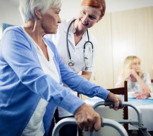 caregiver helping person walk to a table