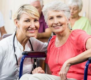 caregiver sitting next to person in a wheelchair